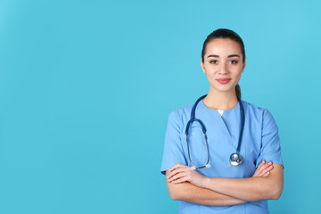 Young medical student in uniform on color background. Space for text