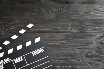 Clapperboard on wooden background, top view with space for text. Cinema production