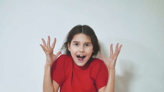 girl screaming opened her mouth. Portrait of adorable surprised little girl. funny child girl with hands close to face background. young girl surprised emotions hands up concept on a white lifestyle