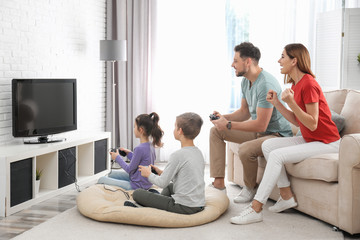 Happy family playing video games in living room