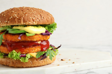 Vegan burger with carrot patties served on table against light background. Space for text