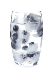 Glass of drink with blueberry ice cubes on white background