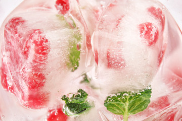 Ice cubes with pomegranate seeds and mint, closeup
