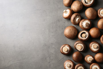 Fresh champignon mushrooms on grey background, top view with space for text