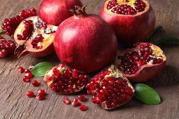 Composition with ripe pomegranates and leaves on color background