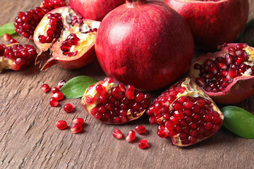 Composition with ripe pomegranates and leaves on color background