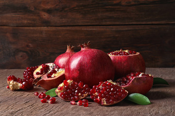 Composition with ripe pomegranates and leaves on table. Space for text