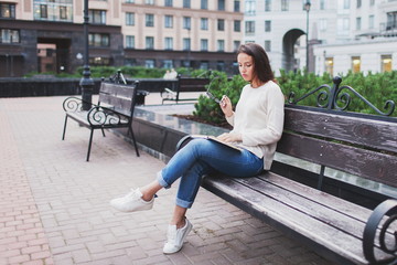 A young beautiful woman reads a paper book.