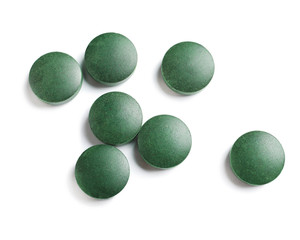 Spirulina tablets on white background, top view. Healthy lifestyle