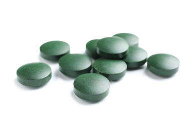 Spirulina tablets on white background. Healthy lifestyle