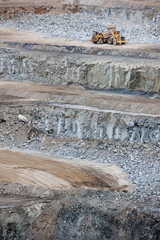 Dumper truck being filled by a bulldozer at a stone quarry in Victoria, Australia