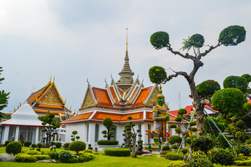 Fototapeta premium Wat Arun, Wat Arunrajawararam, Bangkok. Thai temple, gates with the gigantic guardians protecting it, Thailand, river temple