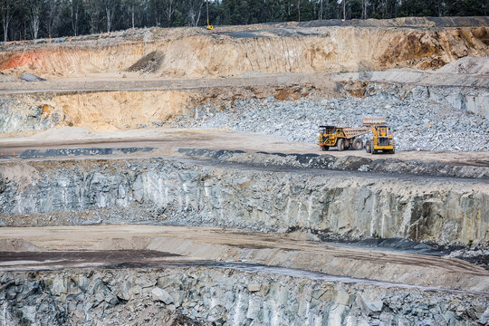 Dumper truck being filled by a bulldozer at a stone quarry in Victoria, Australia
