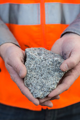Hand holding a piece of quartz stone at a quarry in Victoria Australia