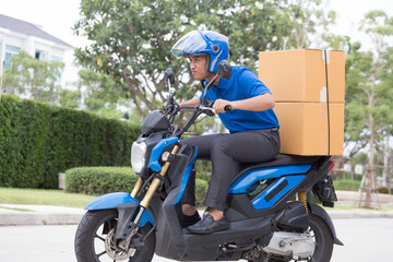 Fototapeta na wymiar Delivery boy on motorcycle with trunk parcel box driving to fast in rush. Courier delivering order online. Express delivery within specified time by scooter concept