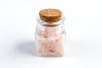 Himalayan pink salt  in a glass jar isolated on white background