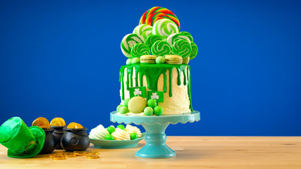 St Patrick's Day party table with lollipop candyland drip cake on blue chroma key background.