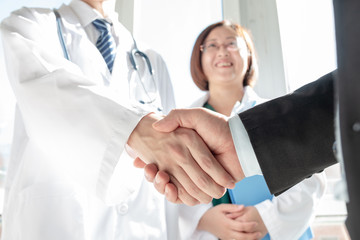Doctor and business people shaking hands - 249958434