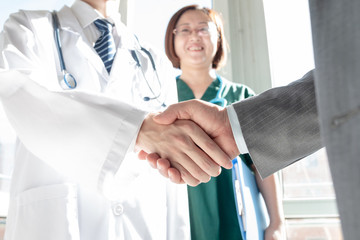 Doctor and business people shaking hands