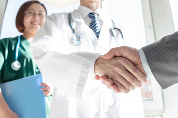 Doctor and business people shaking hands - 249958446