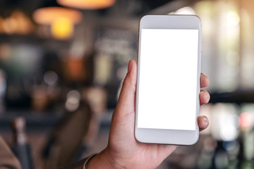 Mockup image of hand holding and showing a white mobile phone with blank screen with blurred background in cafe
