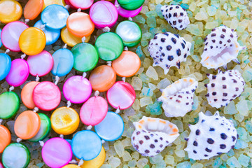 Fototapeta na wymiar Sea Shells and colorful Beads on Crystals of Aromatic Bath Sea Salt for Spa