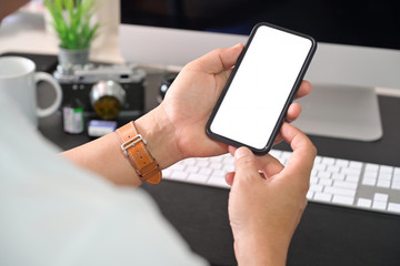 Mobile phone in man hands on workspace