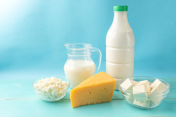 Dairy products. Milk, kefir, cottage cheese, cheese, sour cream, butter, cream and eggs on blue wooden background