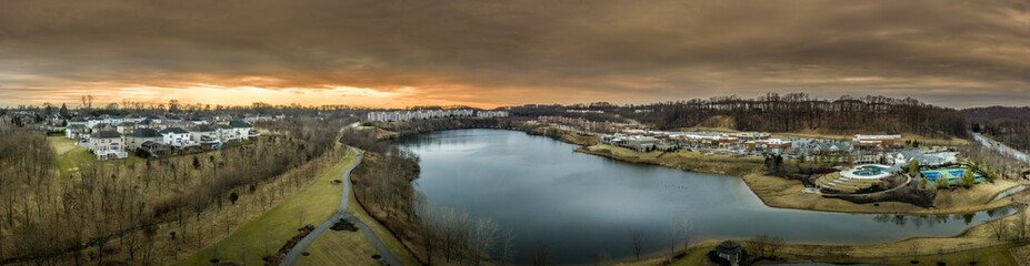 Fototapeta premium Aerial panorama of American luxury real estate neighborhood in Pikesville Maryland with single family houses, mansions, high quality buildings, condos, town houses and shop around a former quarry lake