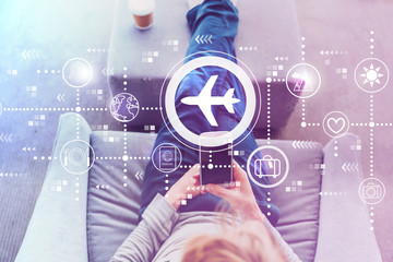 Airplane travel theme with man using a smartphone in a modern gray chair © Tierney