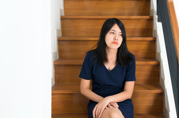 Asian young woman sitting on stair with depression of lonely have a headache,Be absent-minded,Mental disorder health care concept