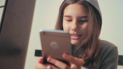 online shopping online retail service based . little teen girl in the hood writes a message chatting in social media messenger. children technology and communication concept. teenage girl with