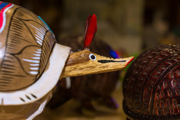 Hay un armadillo artesanal de madera.