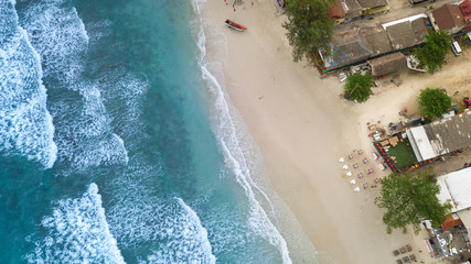 Aerial : Overhead  view at sand  beach resort line ,waves breaking against the coast Haad Rin of koh Phangan island,Thailand
