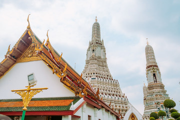 Fototapeta premium Beautiful Thai style temple roof with a view of prang pagoda ancient architecture at wat Arun. Bangkok, Thailand.