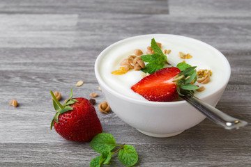strawberry with yogurt and mint in bowl on wood background