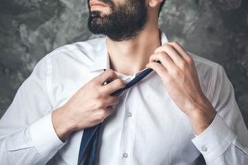 business man remove tie on dark background