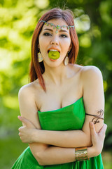 Beautiful young asian woman with slice of kiwi in mouth