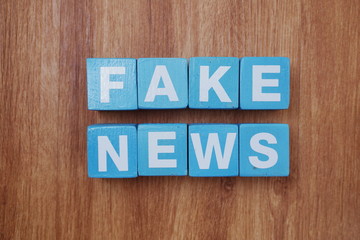 Fake News word alphabet letters on wooden background;