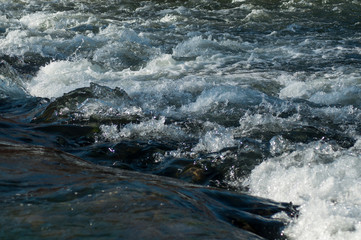 Closeup of water and rocks in the river on mountain