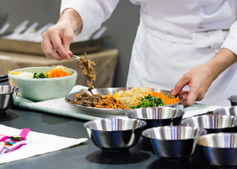 Obraz na płótnie Canvas Bibimbap, Traditional Korean cusine bibimbap, Chef preparing Korean food, chef cooking in kitchen
