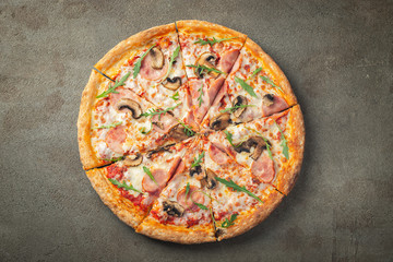 Delicious hot pizza with ham and champignons.
