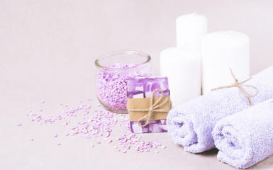 Set for spa treatments. Soft clean towels bath salt a piece of natural soap laid on a light background.