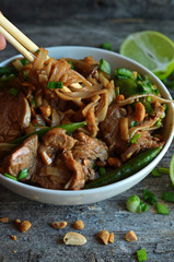 Rice noodles with pork in a white bowl. Asian dish in a bowl