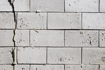 Rough white stone wall with peeling paint grunge vintage texture background