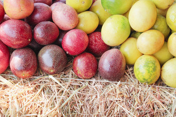 Pile of colorful red and yellow passion fruit on straw rice for background