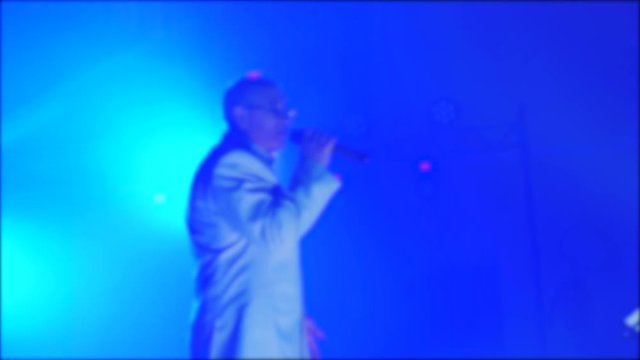 retro music concert blurred background. Senior an old man singing into microphone. slow motion video. retro lifestyle music singer sings on stage beautiful light