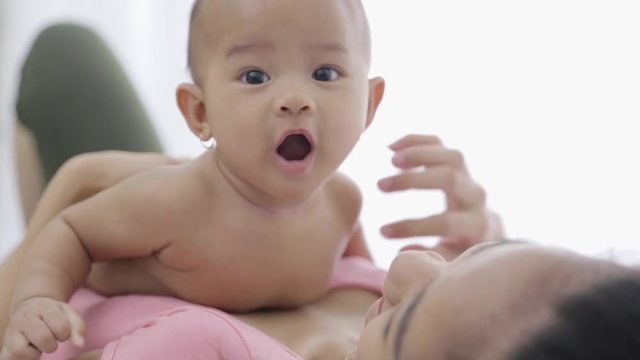 footage of happy cute baby doing tummy time on her mother's belly