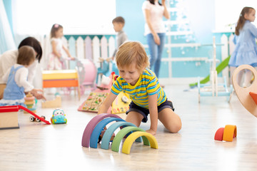 Kids playing on floor with educational toys. Toys for preschool and kindergarten. Children in...