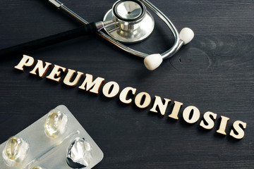 Diagnosis Pneumoconiosis, stethoscope and pills on the desk.